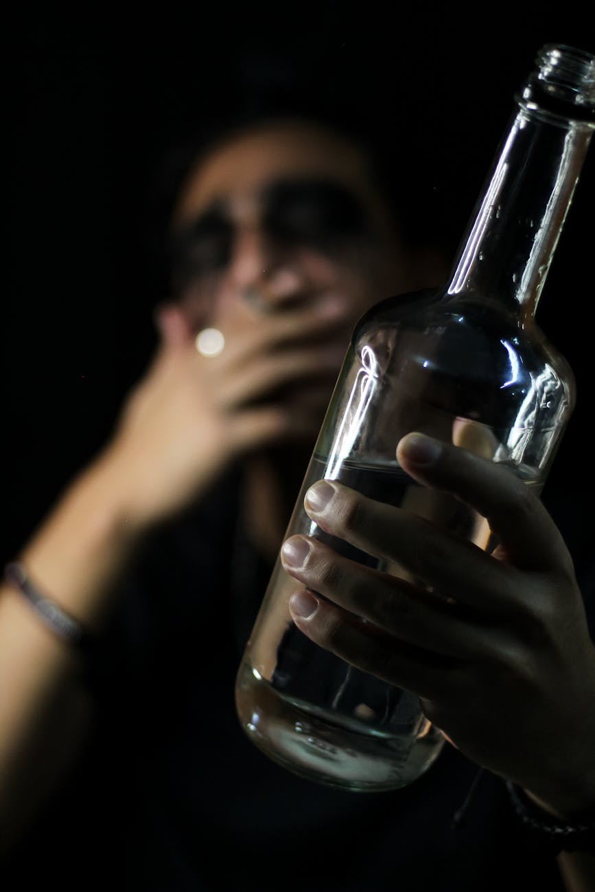 a person holding a bottle of alcohol Antabuse isn't a detox