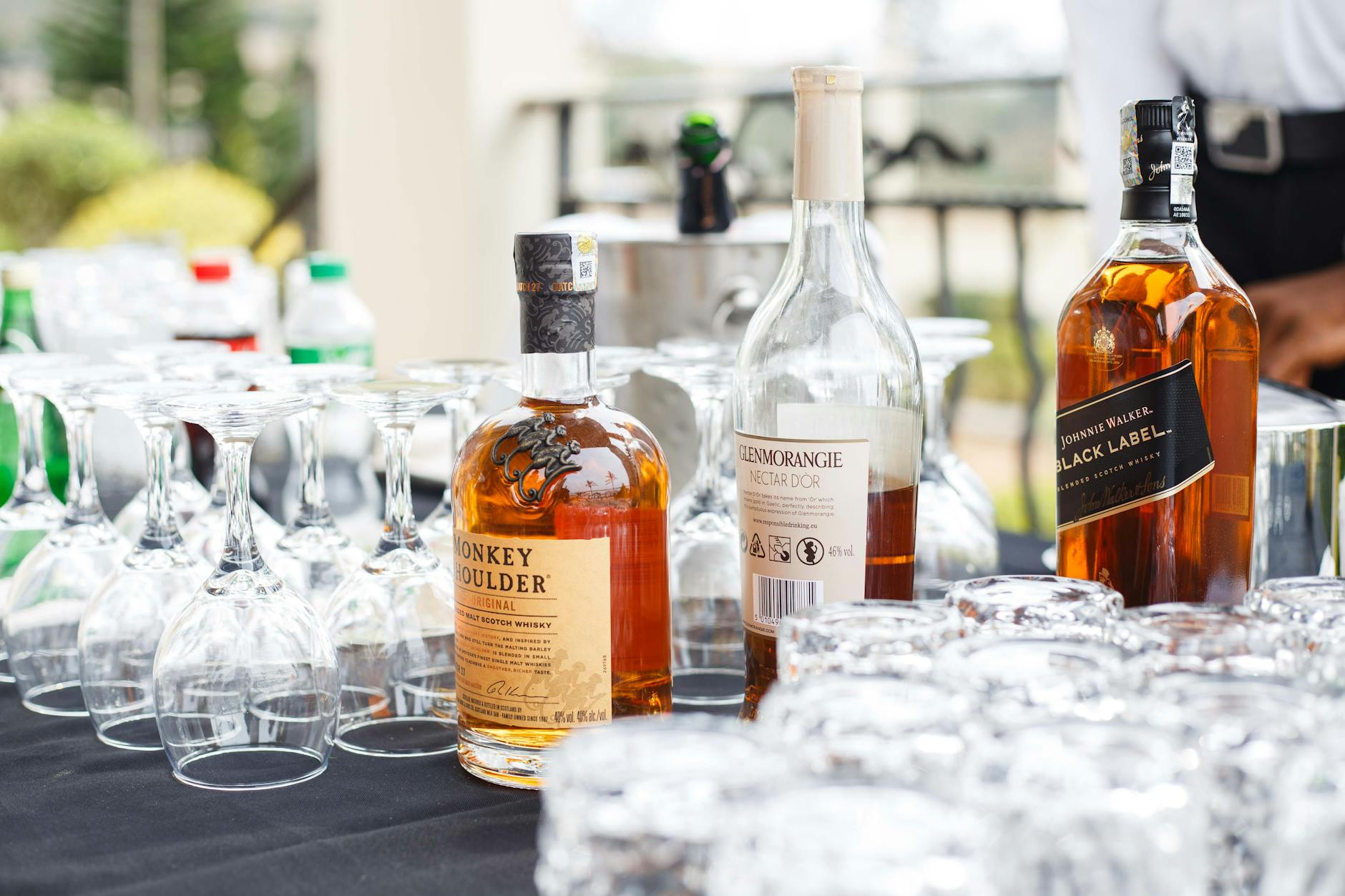 whiskey bottles display with empty glasses outdoors Finding an alcohol treatment centre