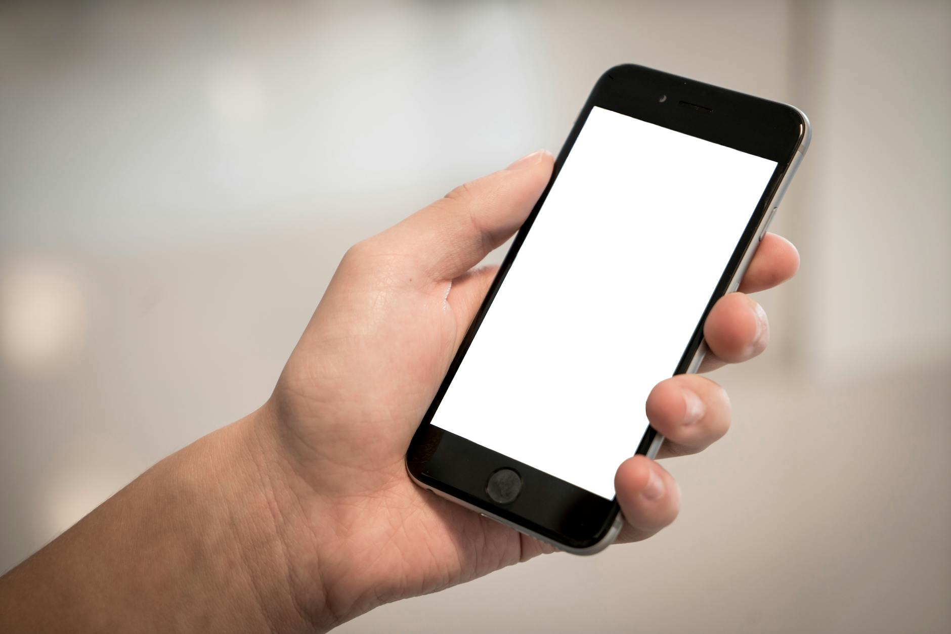 selective focus photography of person holding iphone displaying white screen internet addiction treatment rehab