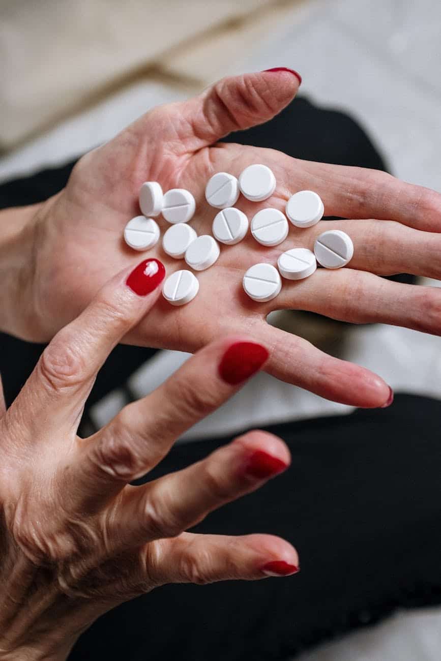 white and orange medication pill on persons hand Rapid alcohol and drug detox