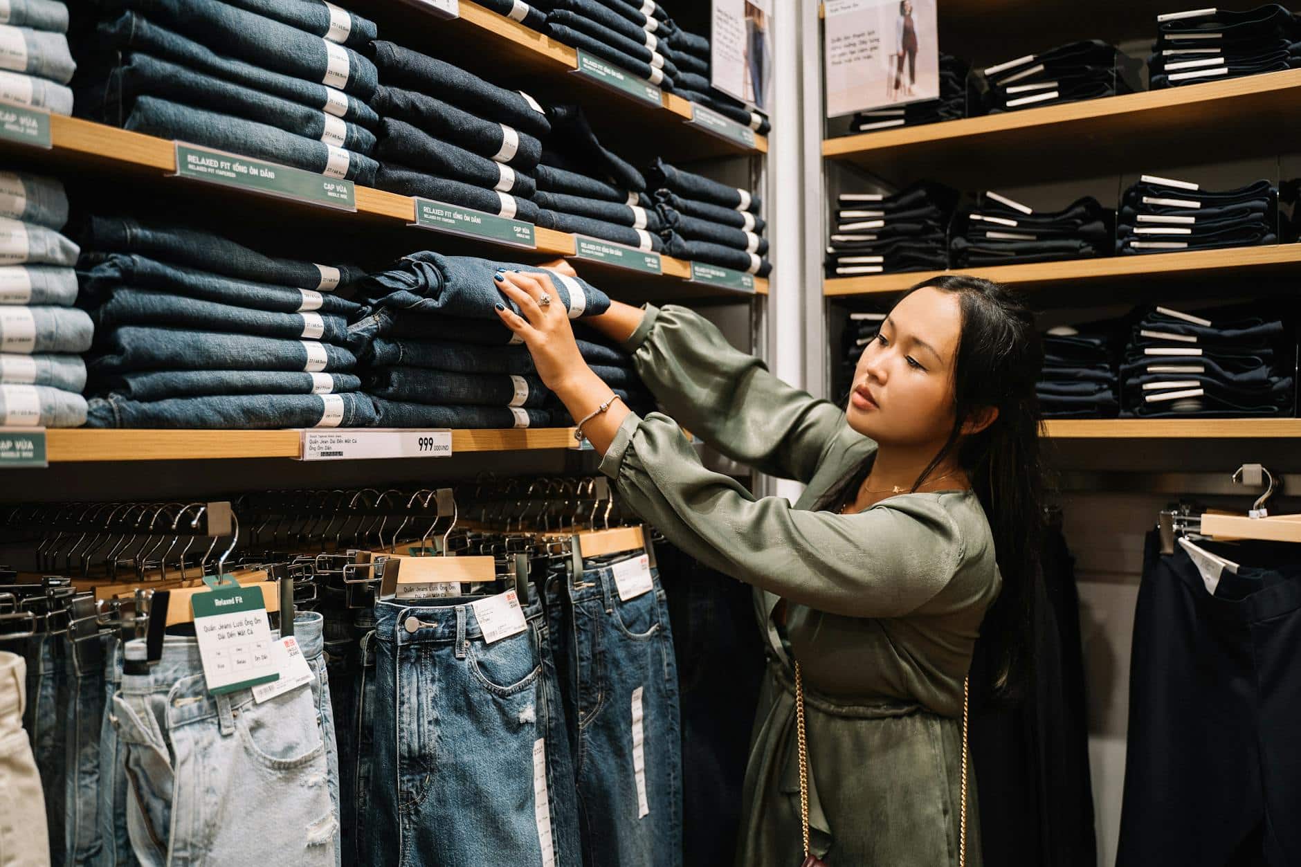 woman looking at the jeans on a wooden shelf shopping addiction detox rehab