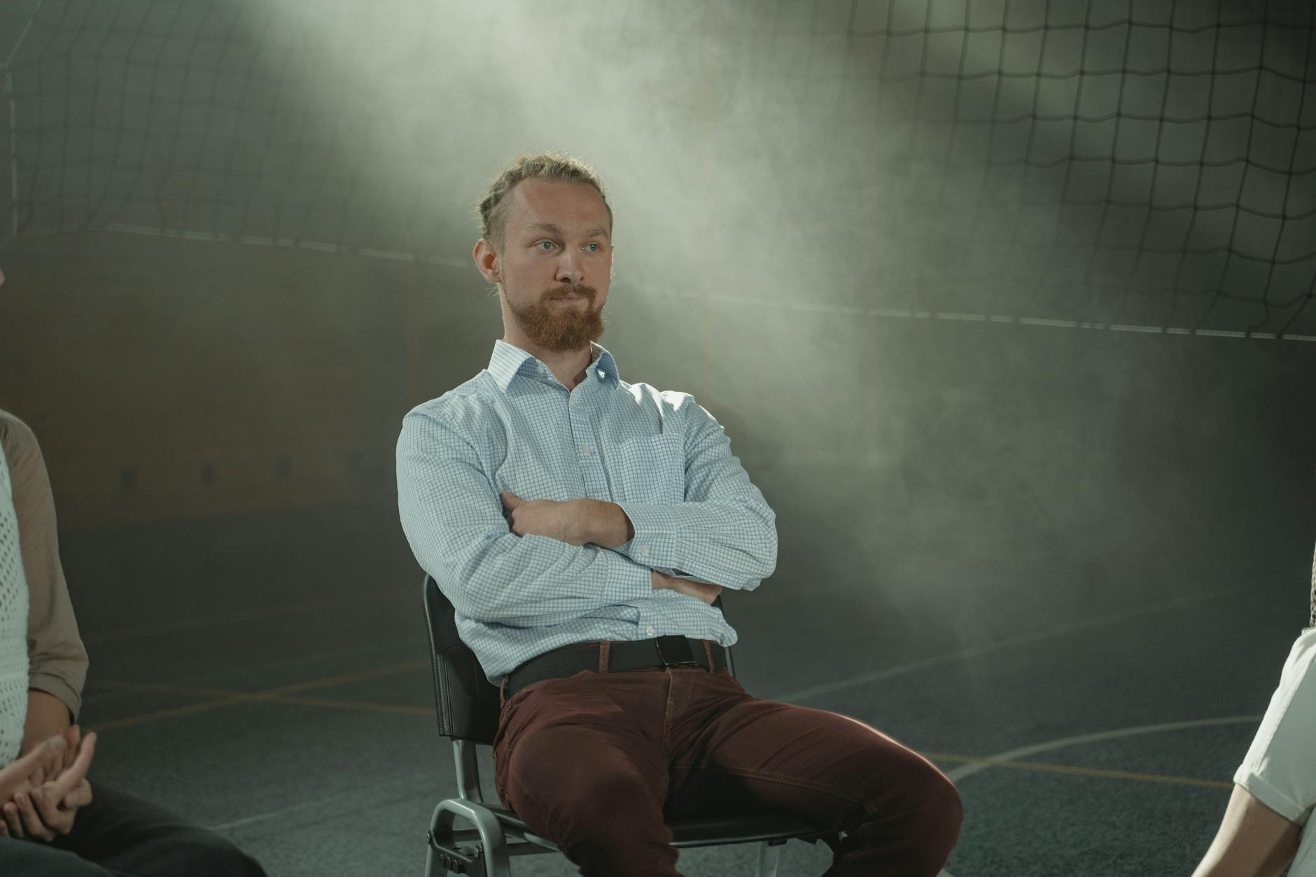 man in white dress shirt sitting on a chair.