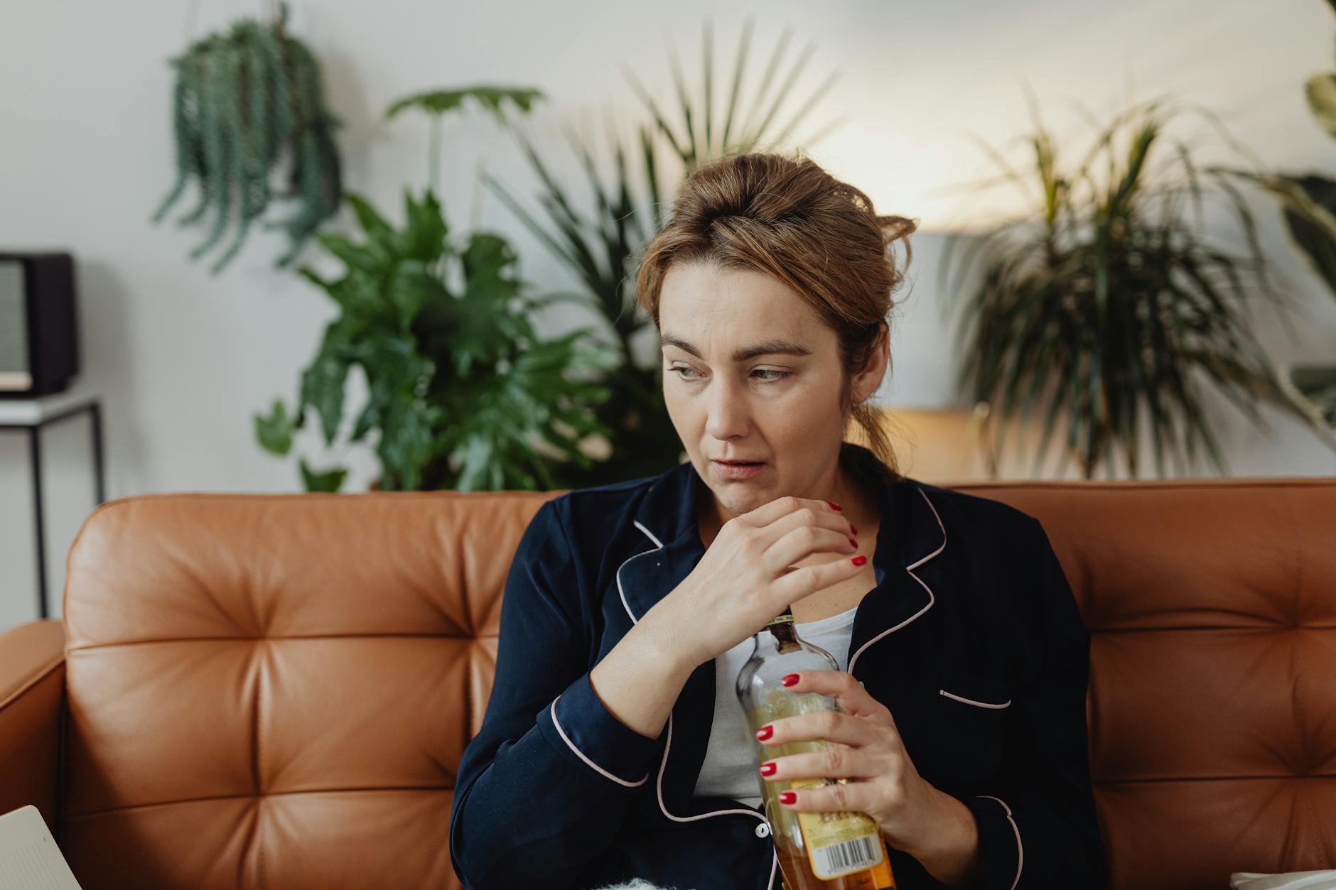 a woman drinking an alcoholic beverage. Home detox or residential rehab