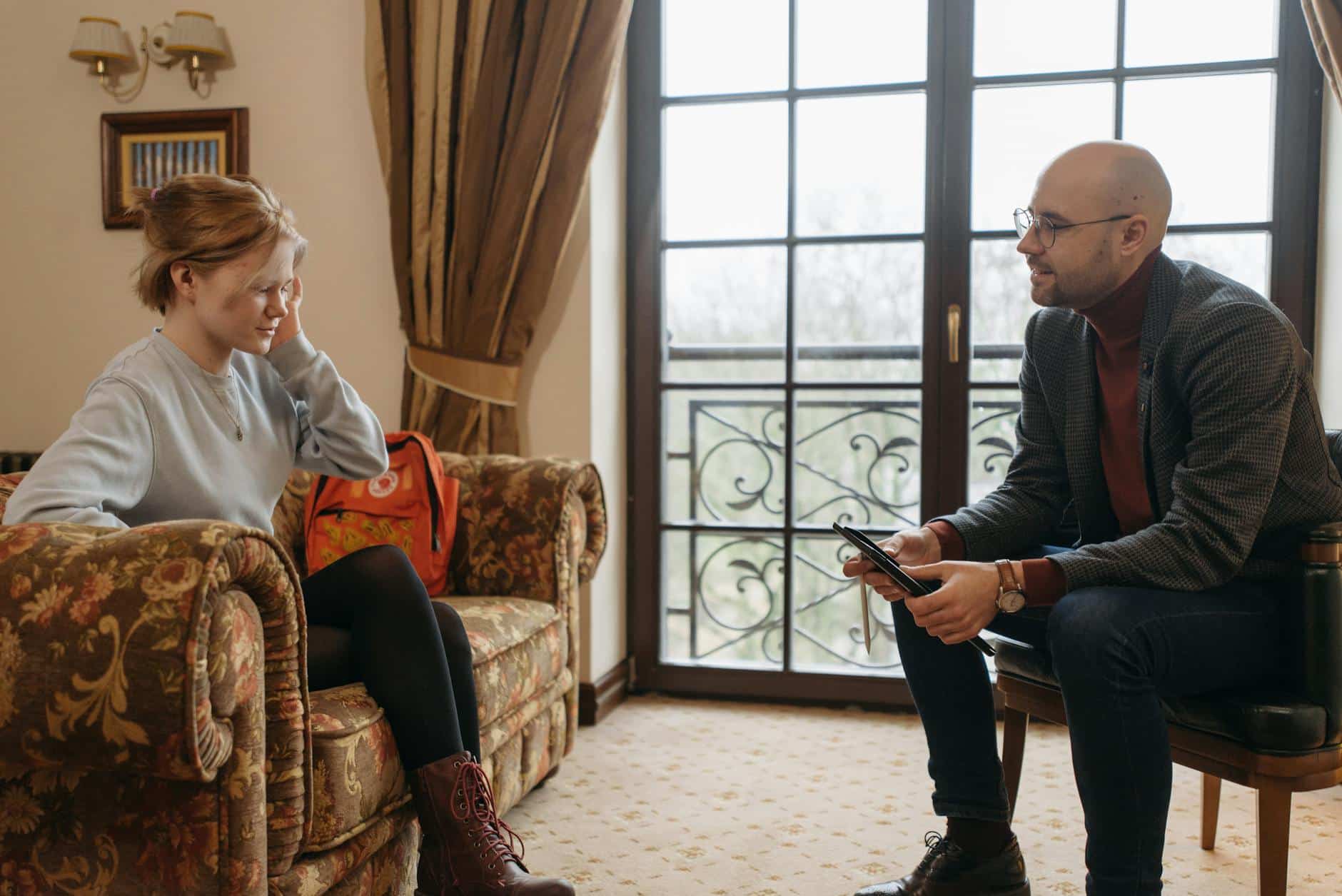 a man talking to a woman sitting on a couch. What to do is someone is addicted