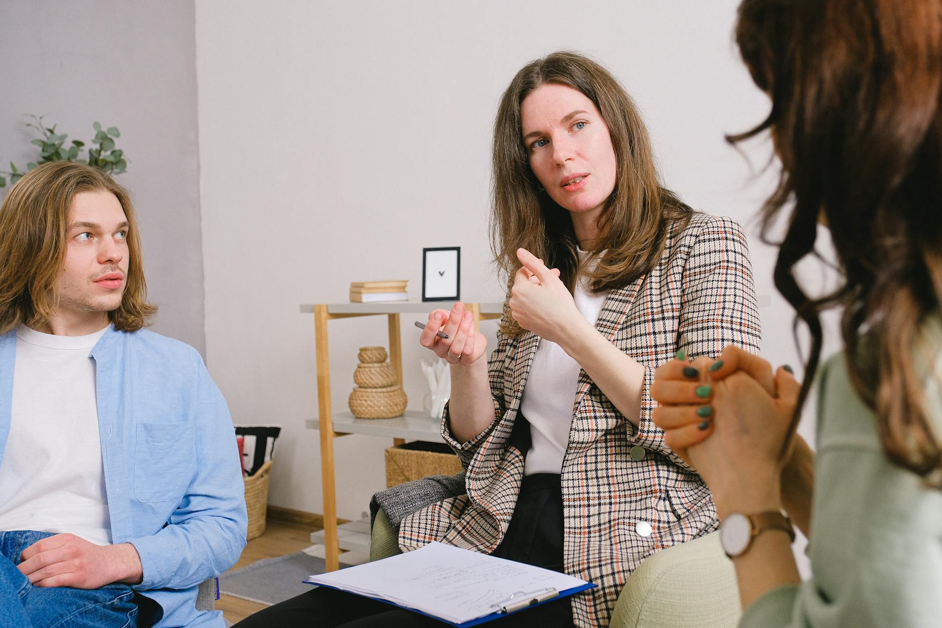 pensive psychologist talking with couple in light room