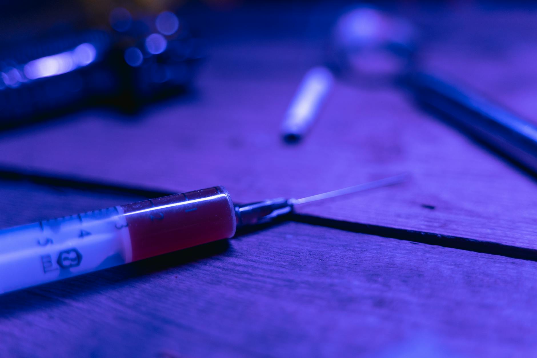 a syringe with brown chemical on a wooden table Understanding Trauma's Role in Addiction Recovery