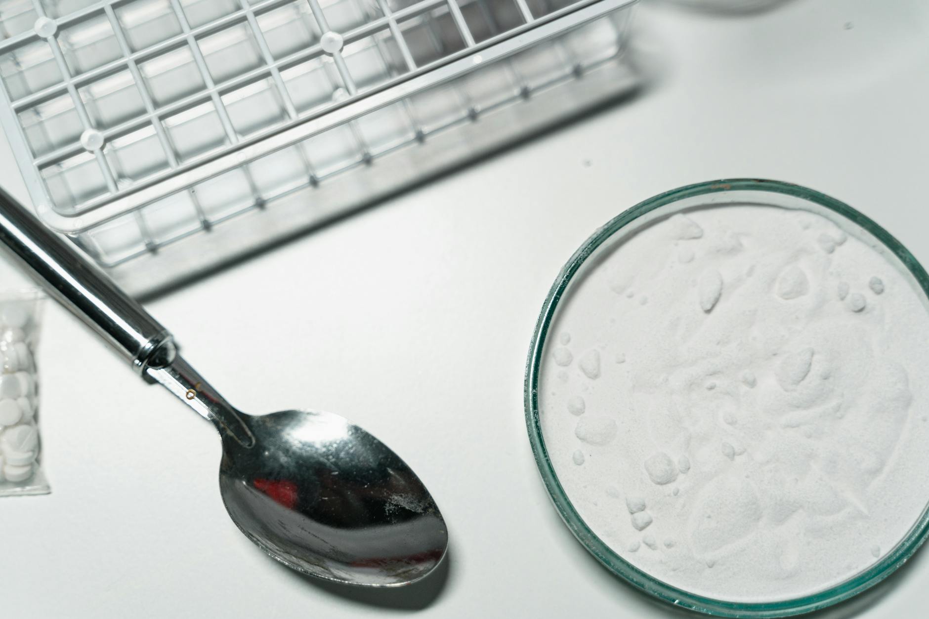 close up shot of silver spoon and illegal drugs on white table. Crack Cocaine Addiction Rehab