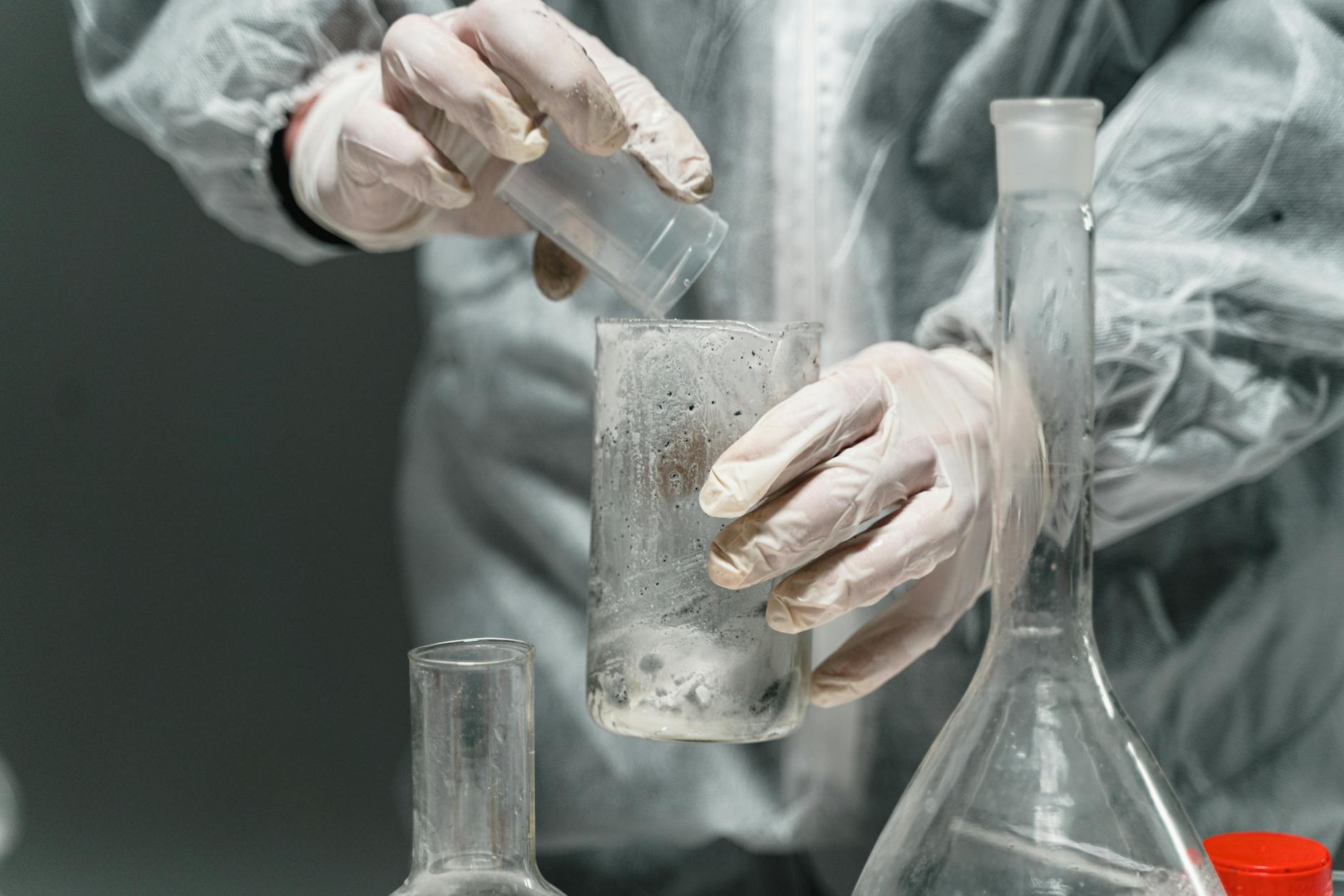 person holding clear glass bottle
