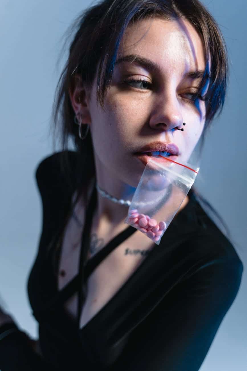 a woman biting a sachet of drugs