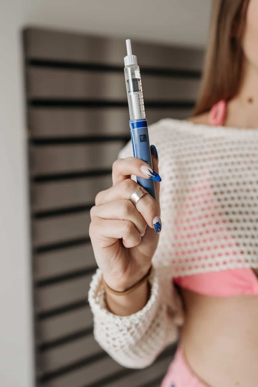 person holding blue and silver glucometer weight loss injection addiction