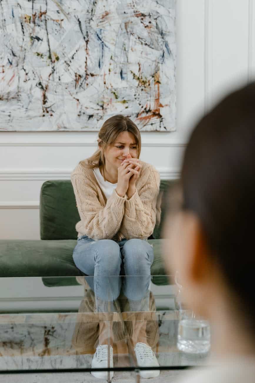 a woman in knitted sweater sitting on the couch. Carfentanil addiction detox rehab