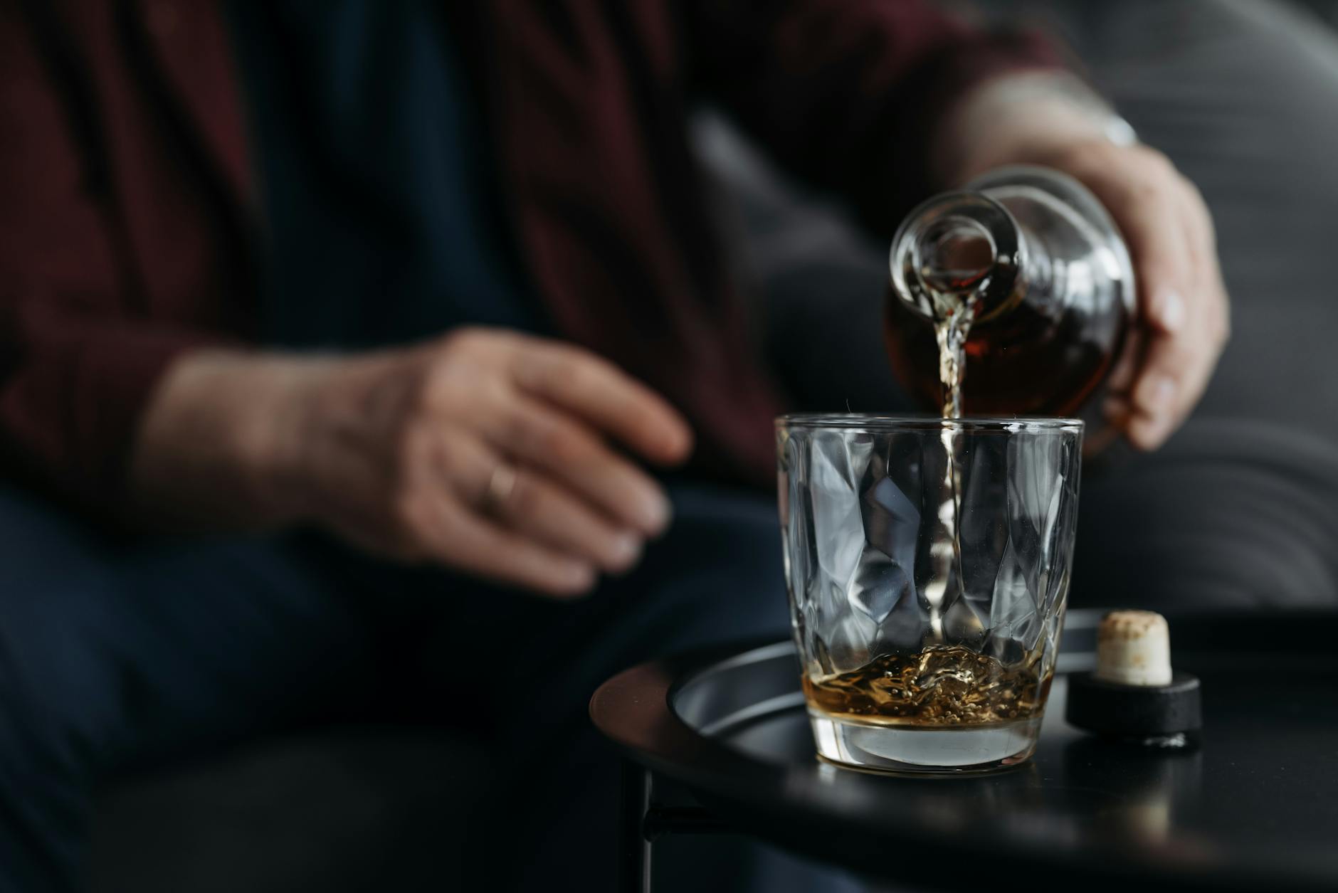a person poring liquor in a glass