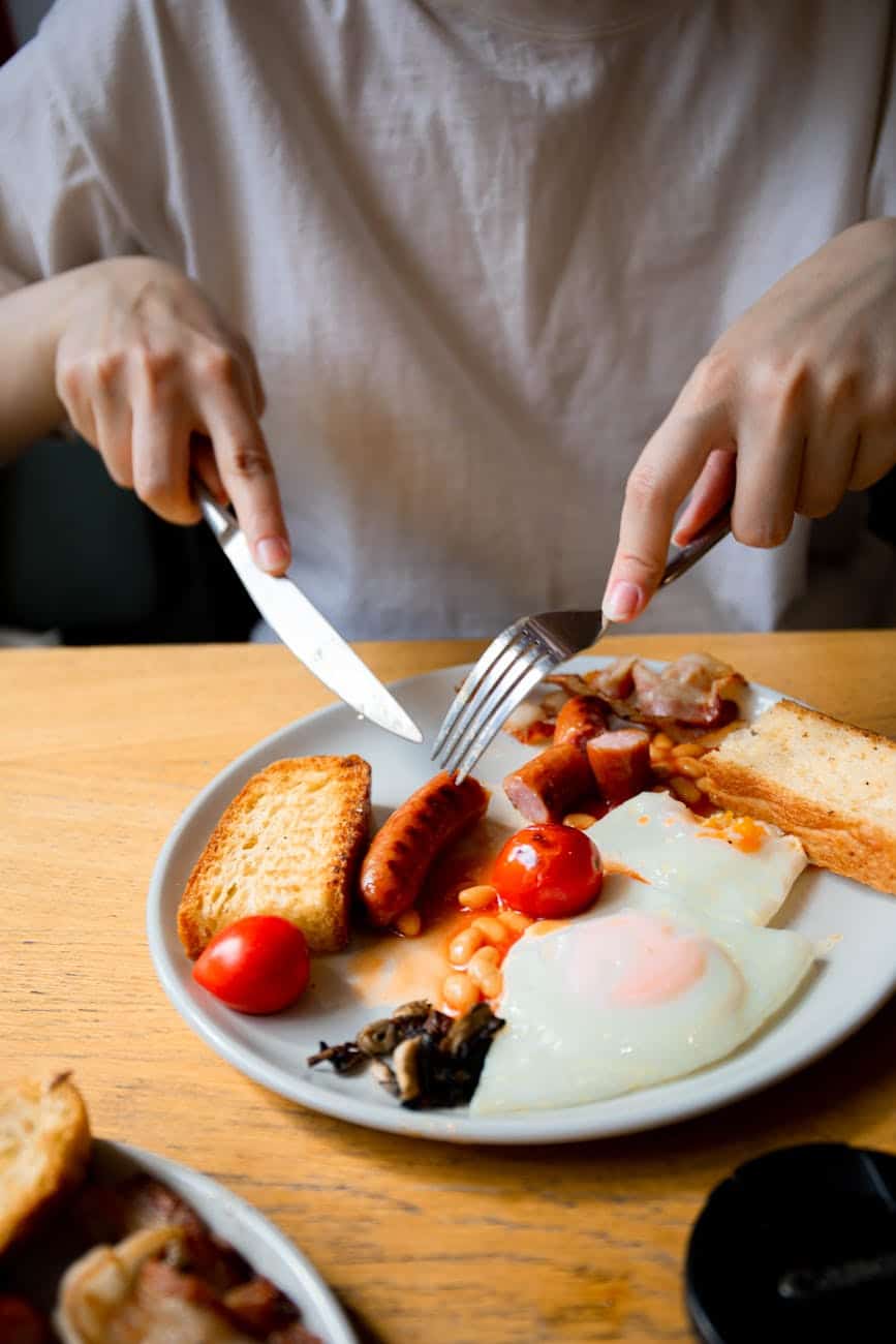 person slicing the food on the plate food addiction