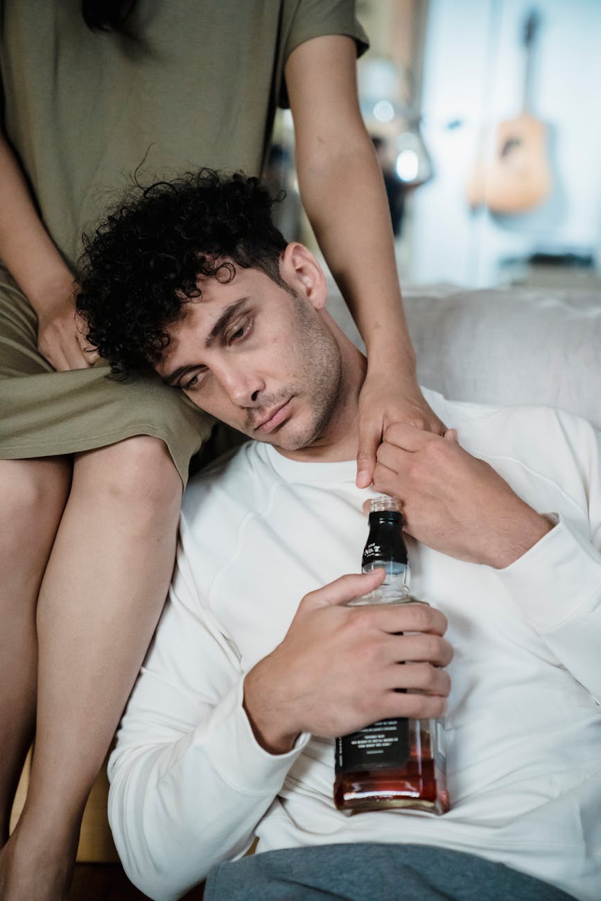 man holding bottle of alcohol Home detox Vs residential rehab. Recognising the signs of alcohol addiction