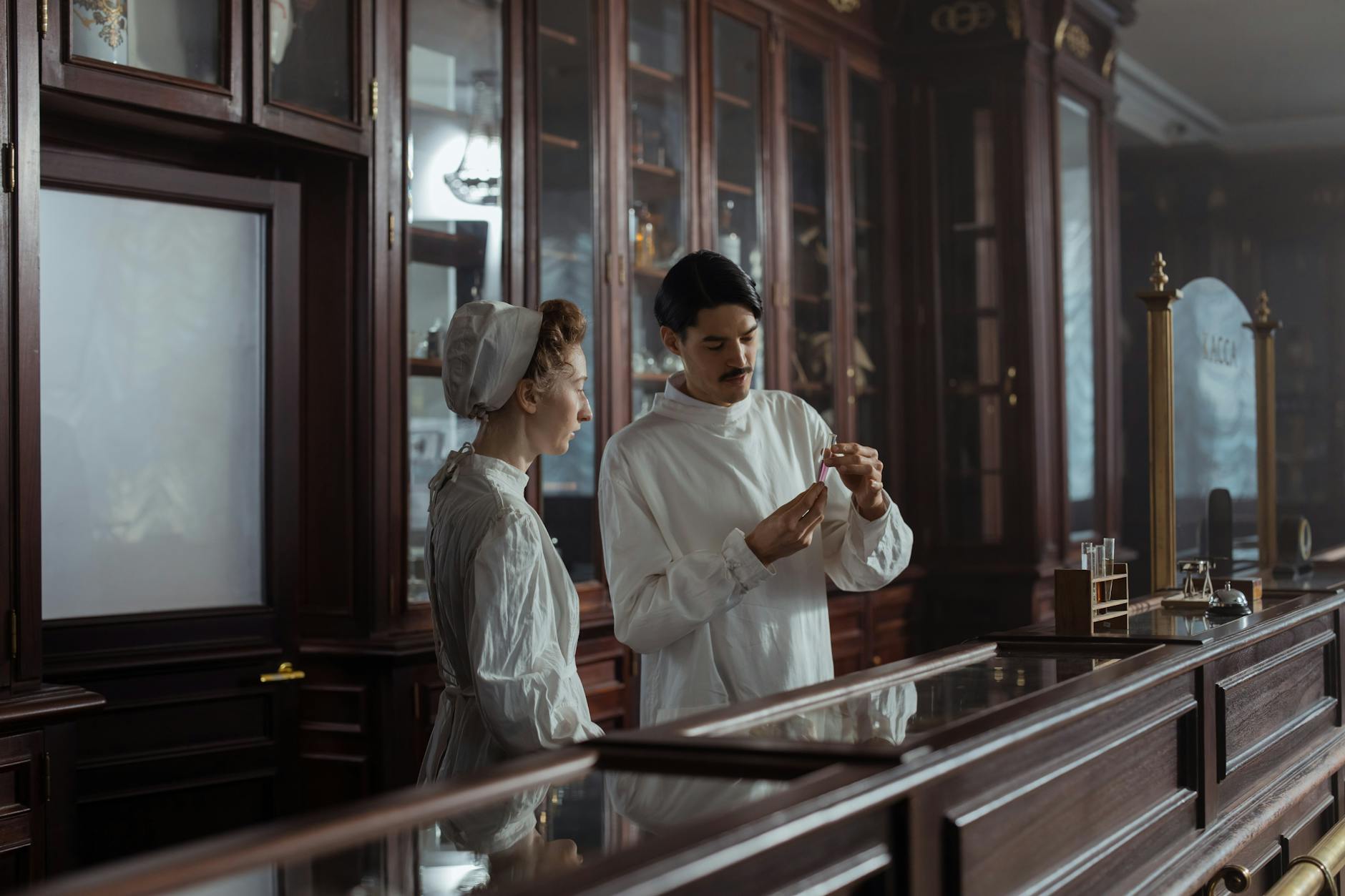 man and woman in white gowns standing behind the counter in a vintage pharmacy Role of medication in addiction treatment